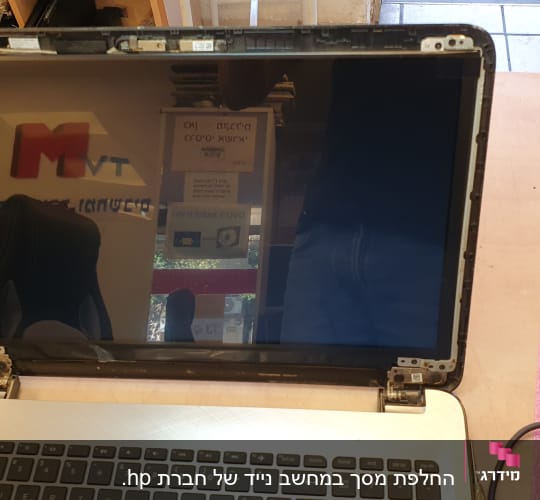 מחשב נייד פתוח עם מסך מפורק על שולחן עבודה